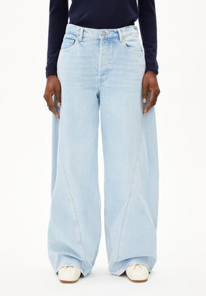 Lichtblauwe wijde jeans met een hoge taille, zichtbare stikseldetails en een licht vervaagde textuur. Voorzien van een knoopsluiting aan de voorkant.