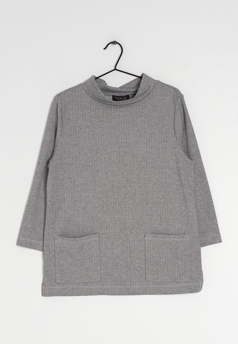 Šedý dlouhý rukáv s vyvýšeným límcem, který má texturovaný rybí kost a dvě přední kapsy. Vyrobeno z měkké tkaniny.