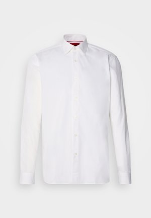 Camicia bianca a maniche lunghe in cotone, con colletto classico, pattina frontale con bottoni e una texture liscia. Dettaglio interno del colletto rosso.