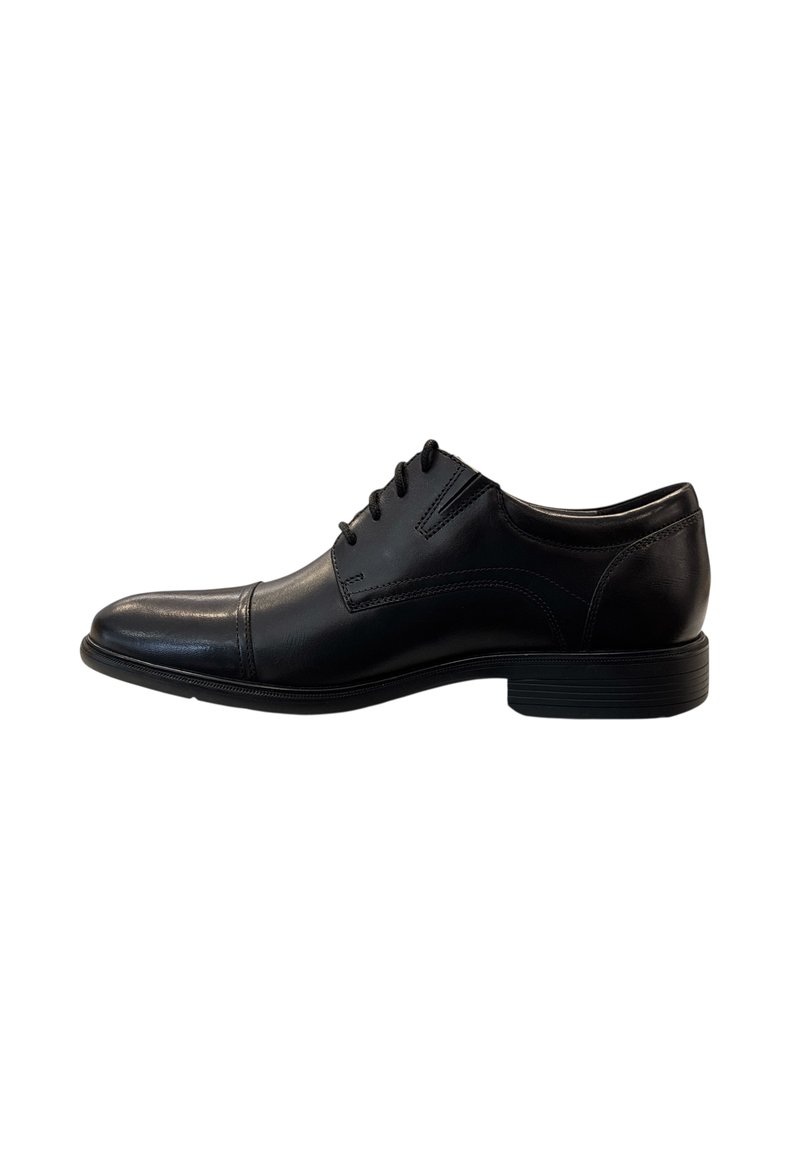 Zapato de vestir de piel negra con textura suave, puntera puntiaguda y diseño de cordones. Presenta costuras sutiles y una suela de goma duradera.