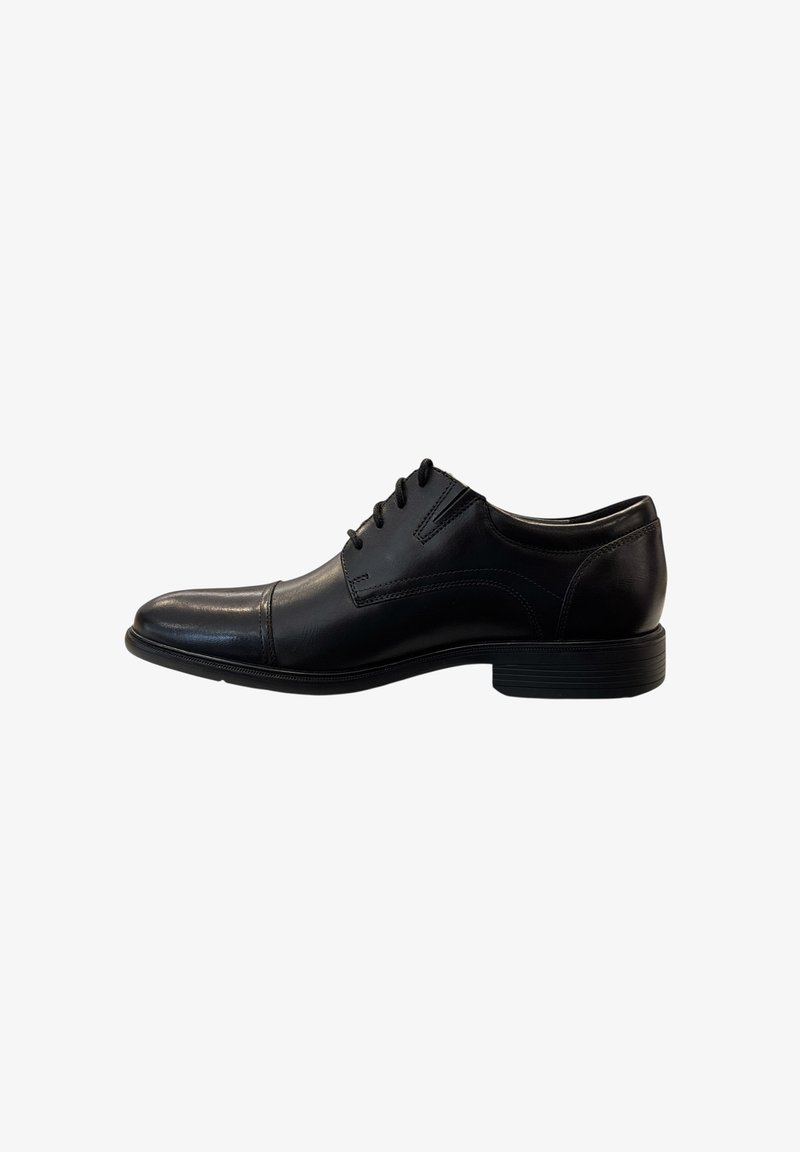 Zapato de vestir de piel negra con textura suave, puntera puntiaguda y diseño de cordones. Presenta costuras sutiles y una suela de goma duradera.