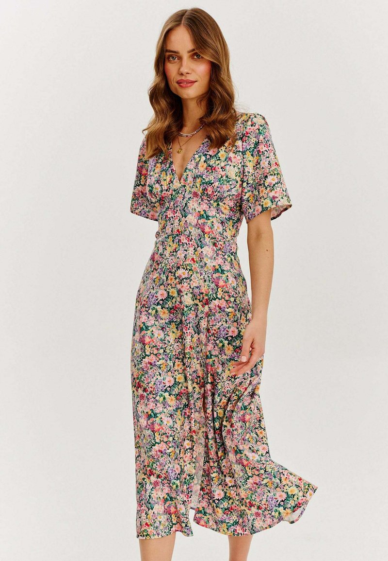 Květinové midi šaty s krátkými rukávy, s výstřihem do V, barevným květinovým vzorem na světlém pozadí a vzdušným střihem.