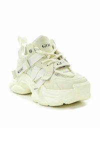 Chunky białe sneakersy łączące gładkie i teksturowane materiały. Regulowane paski i detal z logo podkreślają nowoczesny design.