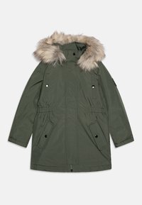 Parka vert olive avec capuche en fausse fourrure, dotée d'une fermeture éclair à l'avant, de poches latérales et d'une taille ajustable pour un ajustement sur mesure. Matériau imperméable.