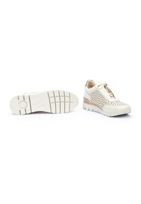 Zapatillas blancas perforadas con cierre de cremallera, parte superior texturizada y suela de goma gruesa. Presentan un acento en rosa claro en el talón.