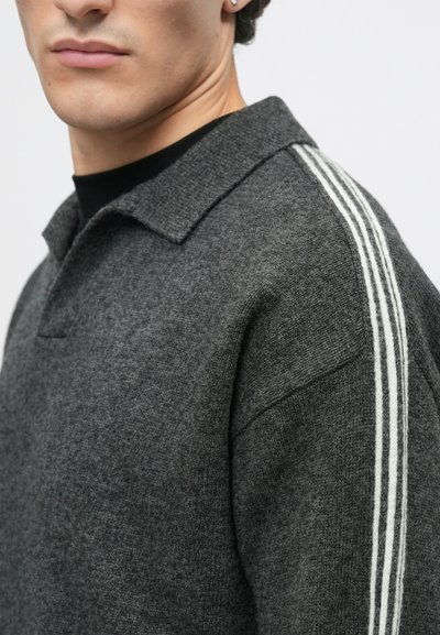 Grijze gebreide poloshirt met een kraag, gekenmerkt door witte strepen langs de schoudernaden; textiel met een zachte uitstraling.
