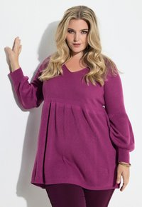 Fialový pletený top s výstřihem do V a balónovými dlouhými rukávy. Látka má ribbovanou texturu a nařasený živůtek pro uvolněný střih.