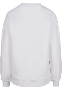 Baltas džemperis su apvalia iškirpte, ilgomis rankovėmis ir ribbintais rankogaliais. Lygus paviršius, be matomų raštų ar detalių. Rodoma nugaros pusė.