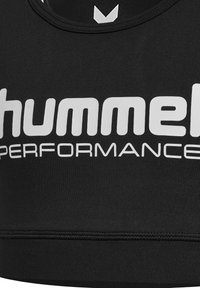 Sort sports-bh med et bredt elastisk bånd; har et hvidt logo "hummel PERFORMANCE" som er fremtrædende vist; glat tekstur.