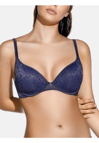 Sujetador de encaje azul marino con un diseño sin costuras, soporte con aros y tirantes delgados ajustables. Presenta un pequeño logo metálico en el centro.