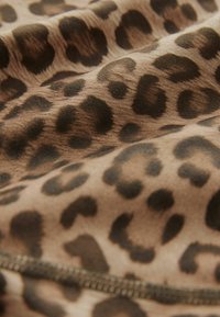 Tela de estampado de leopardo en tonos de marrón y negro, con una textura suave y manchas oscuras prominentes sobre un fondo más claro.