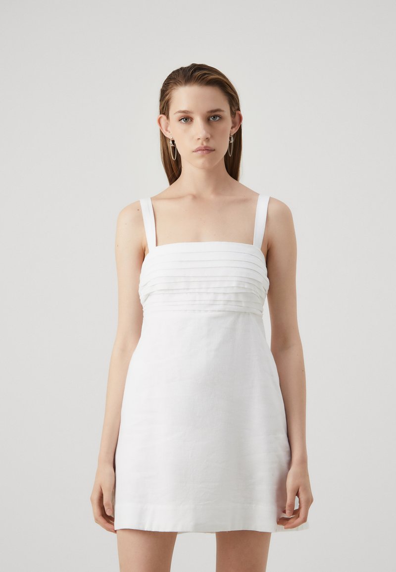 Vestido de lino blanco con un corsé ajustado y pliegues horizontales, tirantes anchos y una falda acampanada. Textura suave, diseño minimalista.