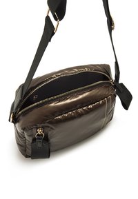 Borsa a tracolla imbottita marrone con zip sulla parte superiore, tracolla nera e accessori in tonalità oro. Presenta una texture liscia e dettagli con tasche laterali.