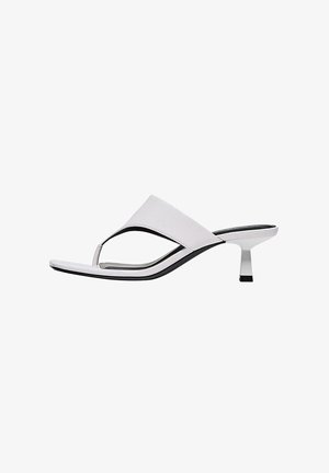 Sandalo con tacco in pelle bianca, con cinturino a infradito, punta aperta e tacco sottile di altezza media su sfondo bianco.