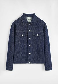 Veste en jean bleu marine foncé avec un motif géométrique subtil, dotée de deux poches poitrine, de boutons-pression en métal argenté et de surpiqûres jaunes contrastantes.