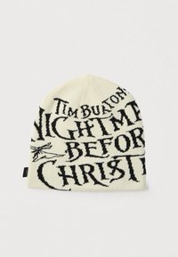 Πλεκτός σκούφος σε εκρού χρώμα με μαύρη τυπογραφία. Φέρει τίτλους από το "Ο Εφιάλτης πριν τα Χριστούγεννα," απαλή υφή και αδιάκοπη σχεδίαση.