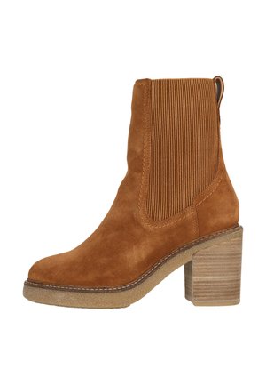Brown suede ankle boot with ribbed elastic side panels, stacked wooden heel, and textured sole. Features a pull tab for easy wear.