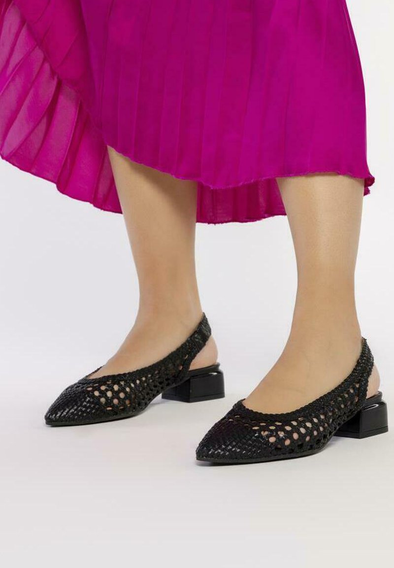 Bailarinas negras con tiras traseras, con un patrón tejido, punta afilada y tacón bajo en bloque, que presentan un diseño texturizado y abierto.