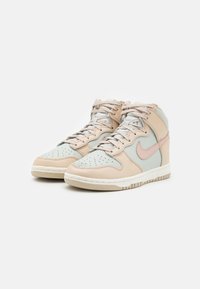 Höga sneakers med en blandning av ljusbeige läder och mintgröna accenter. Perforerad tåbox och rosa Nike swoosh-logotyp. Gummisula.
