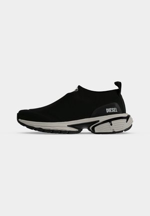 Sneaker slip-on nero con suola spessa grigia e logo Diesel sul lato del tallone, tomaia elastica e linguetta posteriore.
