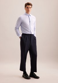 Jasnoniebieska i biała koszula w kratkę z długim rękawem, zestawiona z granatowymi spodniami w kant i czarnymi butami eleganckimi. Prosty design, dopasowany krój.
