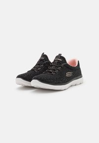 Black sneakers with a leopard print texture, featuring elastic laces and a pink interior. White rubber sole with logo detail.