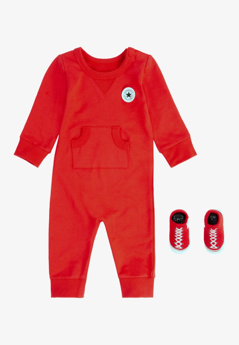 Rød bomulls onesie med lange ermer, som har en frontlomme og en rund logo. Inkluderer matchende røde stoffsko med hvite lisser.