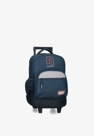 Mochila con ruedas azul marino de Reebok con bolsillo delantero con cremallera, bolsillo lateral de malla, asa acolchada y base con ruedas resistente para un transporte fácil.