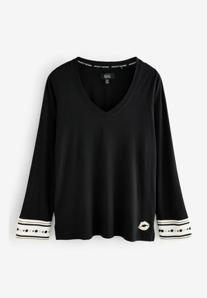Schwarzes Langarm-T-Shirt mit V-Ausschnitt, mit gestreiften Bündchen und Mustern sowie einem Lippenprint-Detail unten links. Weicher Stoff.