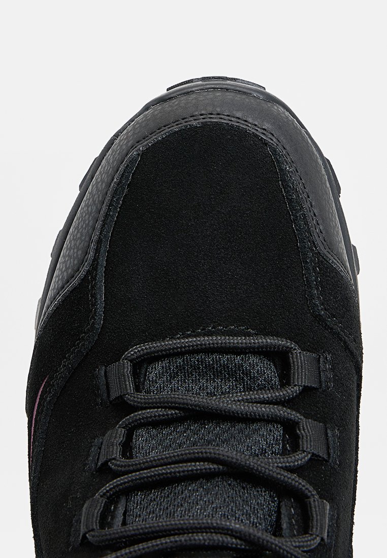 Schwarzer Sneaker mit Obermaterial aus Wildleder und Textil. Verfügt über eine abgerundete Zehenpartie, runde Schnürsenkel und eine Gummisohle. Minimalistisches Design mit strukturierten Akzenten.