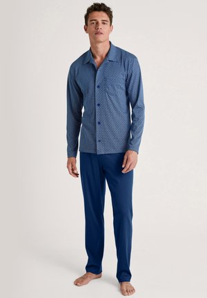 Navyblauwe pyjama set met een patroon, bestaande uit een knoop-over lange mouwen overhemd met geometrische ontwerpen en bijpassende effen blauwe broek.