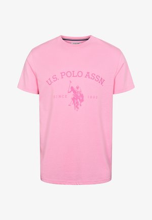 Vaaleanpunainen puuvillapaitapusero, jossa on pyöreä kaula-aukko, lyhyet hihat ja etupuolella logo, joka kuvaa polo-ottelua sekä teksti "U.S. POLO ASSN. SINCE 1890."