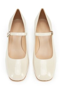 Scarpe Mary Jane in pelle verniciata beige con punta quadrata, dotate di una sola fascia e fibbia metallica. Interno morbido, dettagli minimi.