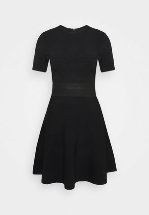 Robe noire à manches courtes avec un corsage ajusté et une jupe évasée. Texture côtelée avec une bande unie à la taille arborant un détail de logo.