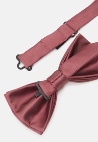 Burgunderfarvet silke butterfly med plisseret design, der har en sort forbindelsesklips og justerbar rem for en sikker pasform.