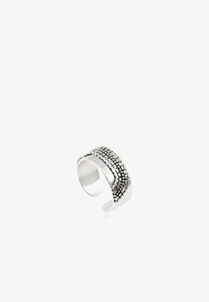 Bague manchette ouverte en argent avec motif texturé de points carrés sur la surface supérieure, intérieur poli lisse, reflétant la lumière sur fond blanc.