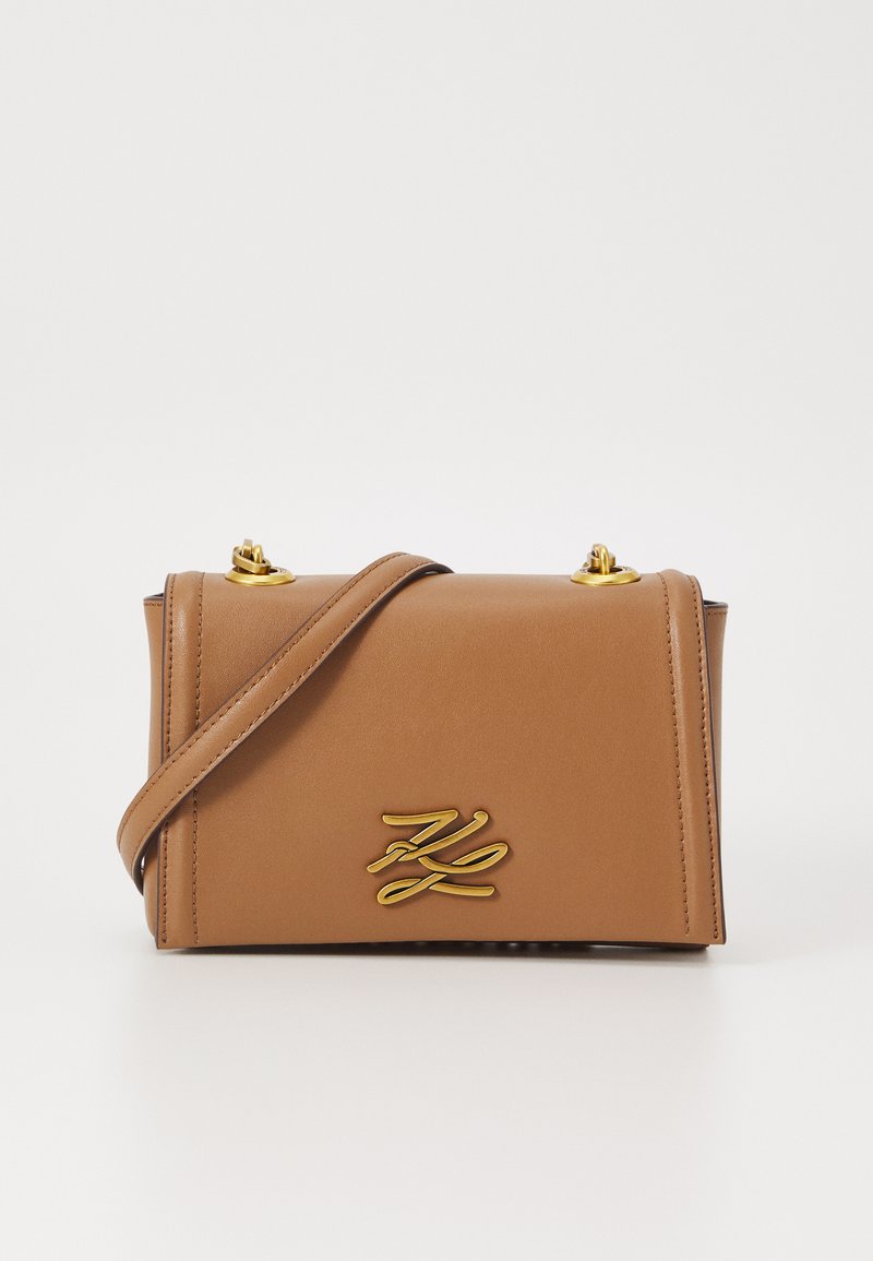 Borsa a tracolla in finta pelle marrone con dettagli in oro, design a pattina classico e un logo in rilievo ben visibile sul fronte.