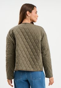Gepolsterte, olivgrüne Jacke mit einer kastigen Silhouette und rundem Halsausschnitt. Verfügt über eine Diamantsteppung und subtile seitliche Details.