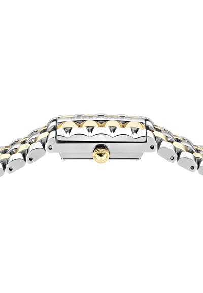 Hõbedane ja kullatooniga metallkell, millel on ristkülikuline kellanägu, sujuv lingiäär ja poleeritud viimistlus. Silmapaistvad soonilised aktsendid korpusel.