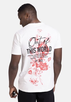 White cotton t-shirt with a floral red print and black text on the back. Features a crew neck and short sleeves, relaxed fit.