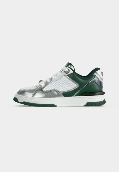 Sneakers basses avec des panneaux blancs, verts et argentés, des lacets blancs, des motifs embossés et une semelle blanche épaisse avec des accents verts.