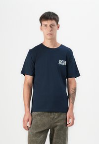 Navy blue crew-neck t-shirt made of cotton with short sleeves, featuring a multi-colored "JACK & JONES" logo on the left chest.