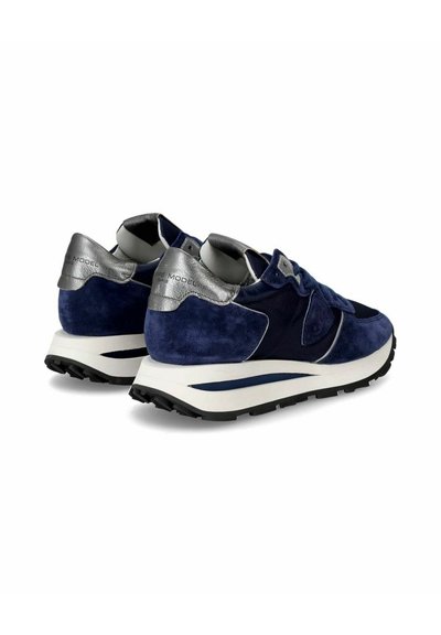 Mørkeblå ruskindssneakers med metallisk sølvaccent og en polstret hvid sål. Har en tekstureret stofoverdel og gummisål med godt greb.