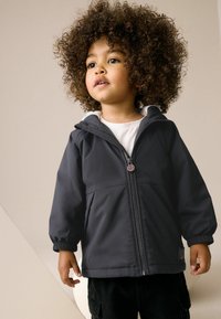 Veste noire pour enfants avec fermeture éclair et capuche. Dotée de poignets élastiques et d'un patch logo. Texture douce et lisse, adaptée pour les vêtements d'extérieur.