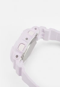 Reloj de silicona morado con botones texturizados y caja metálica. Presenta una correa ancha y superficie lisa, destacando un diseño funcional.