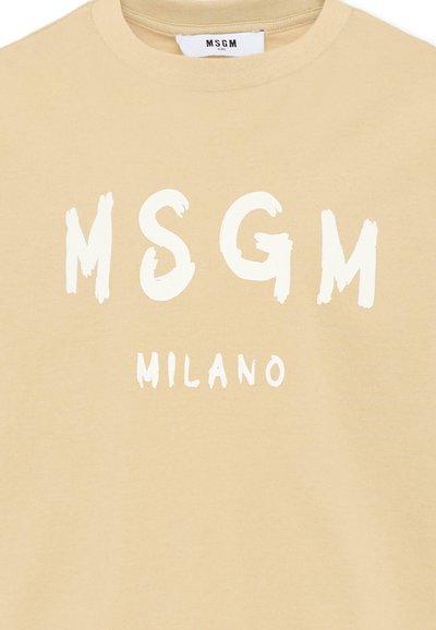 T-shirt beige avec de grandes lettres blanches style coup de pinceau "MSGM" et un texte plus petit "MILANO" en dessous à l'avant.