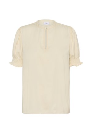 Blouse couleur crème avec manches courtes bouffantes, poignets froncés et encolure avec ouverture en forme de clé. Tissu doux avec une texture lisse.