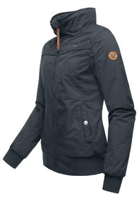 Veste isolée marine avec un col haut, un zip frontal, une poche zippée et des poignets côtelés. Présente un logo en cuir circulaire sur la manche.