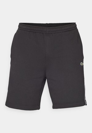 Șorturi sportive negre, dintr-un material moale, cu talie elastică, dungi pe laterale și un mic logo brodat pe față.