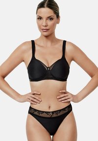 Ensemble de lingerie noire comprenant un soutien-gorge à bonnets moulés et à accents en dentelle, accompagné de culottes taille haute assorties avec des bordures en dentelle florale.